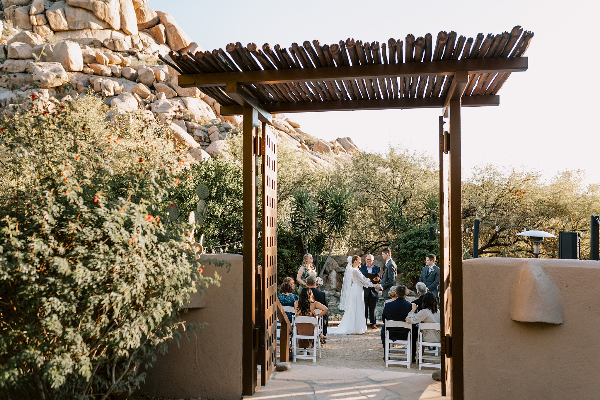 Bride and groom exchanging vows in the organic garden at The Boulders Resort, Scottsdale, with stunning desert scenery in the background.