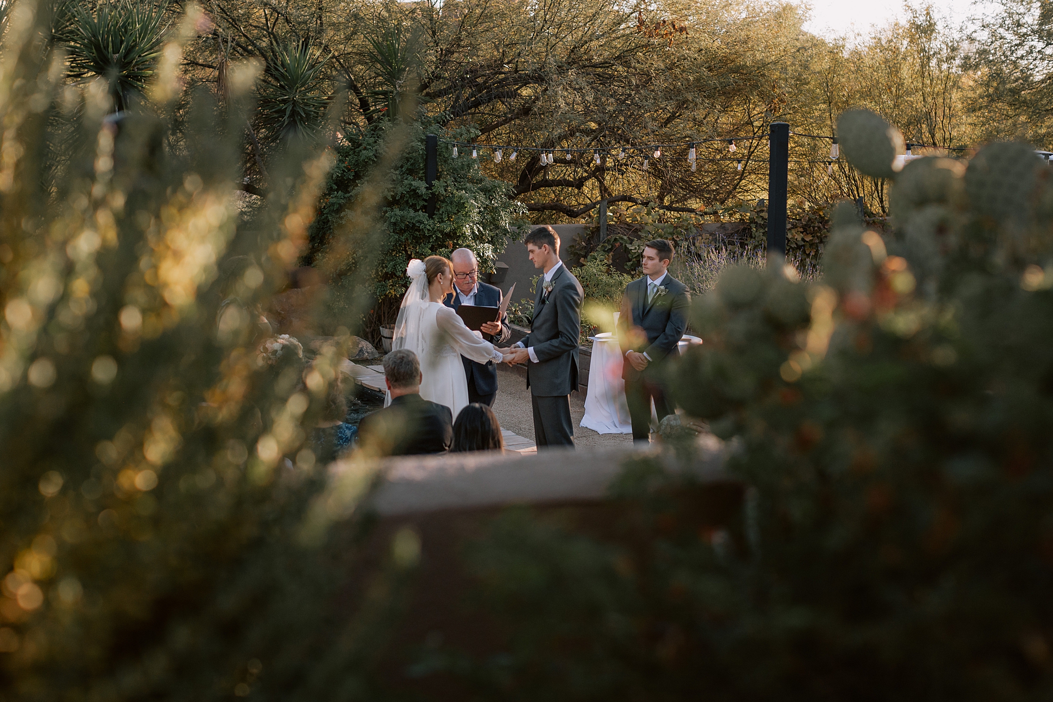 Bride and groom exchanging vows in the organic garden at The Boulders Resort, Scottsdale, with stunning desert scenery in the background.