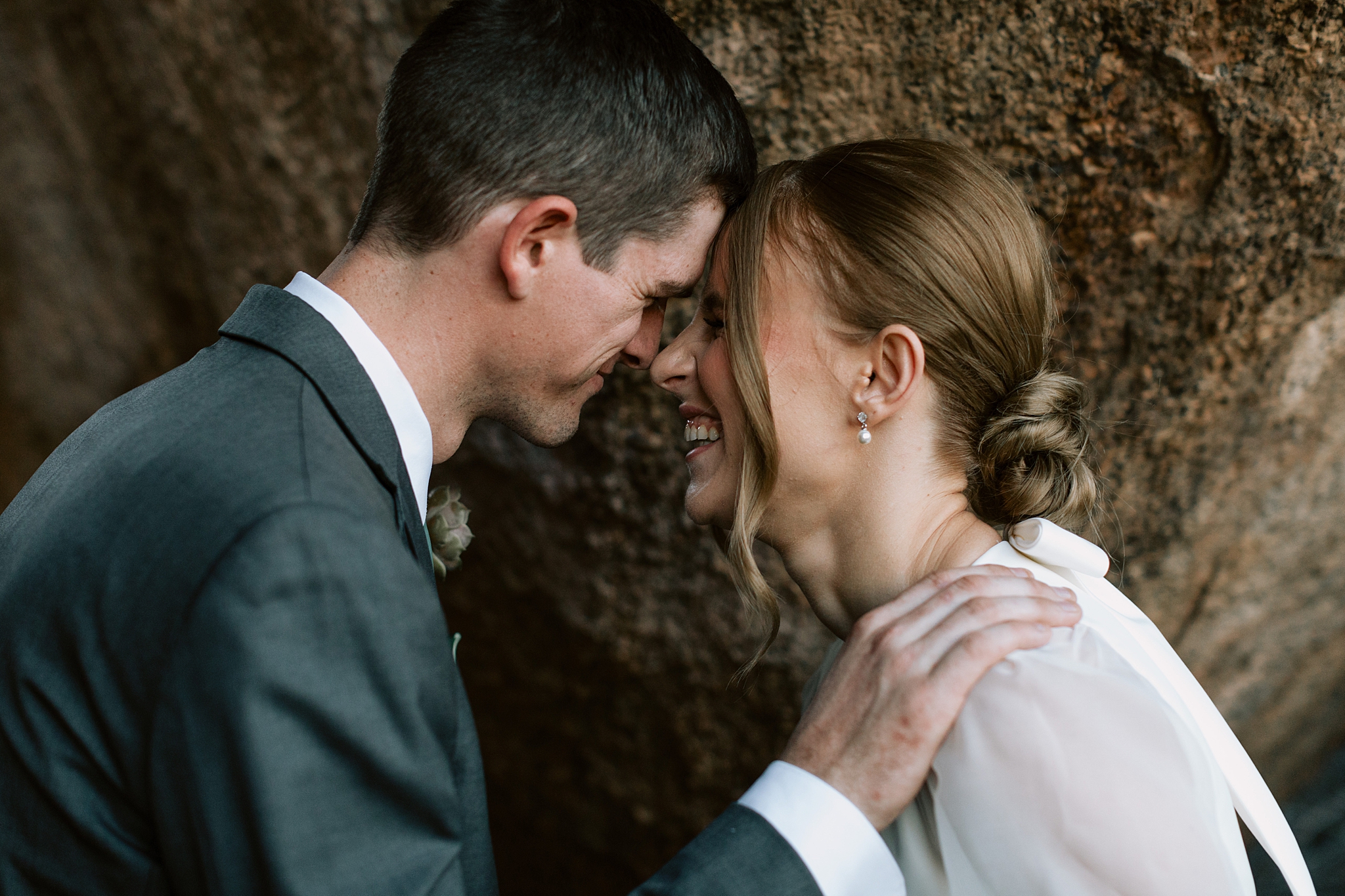 Newlyweds laughing together in the desert garden at The Boulders Resort, capturing a joyful and intimate wedding moment.