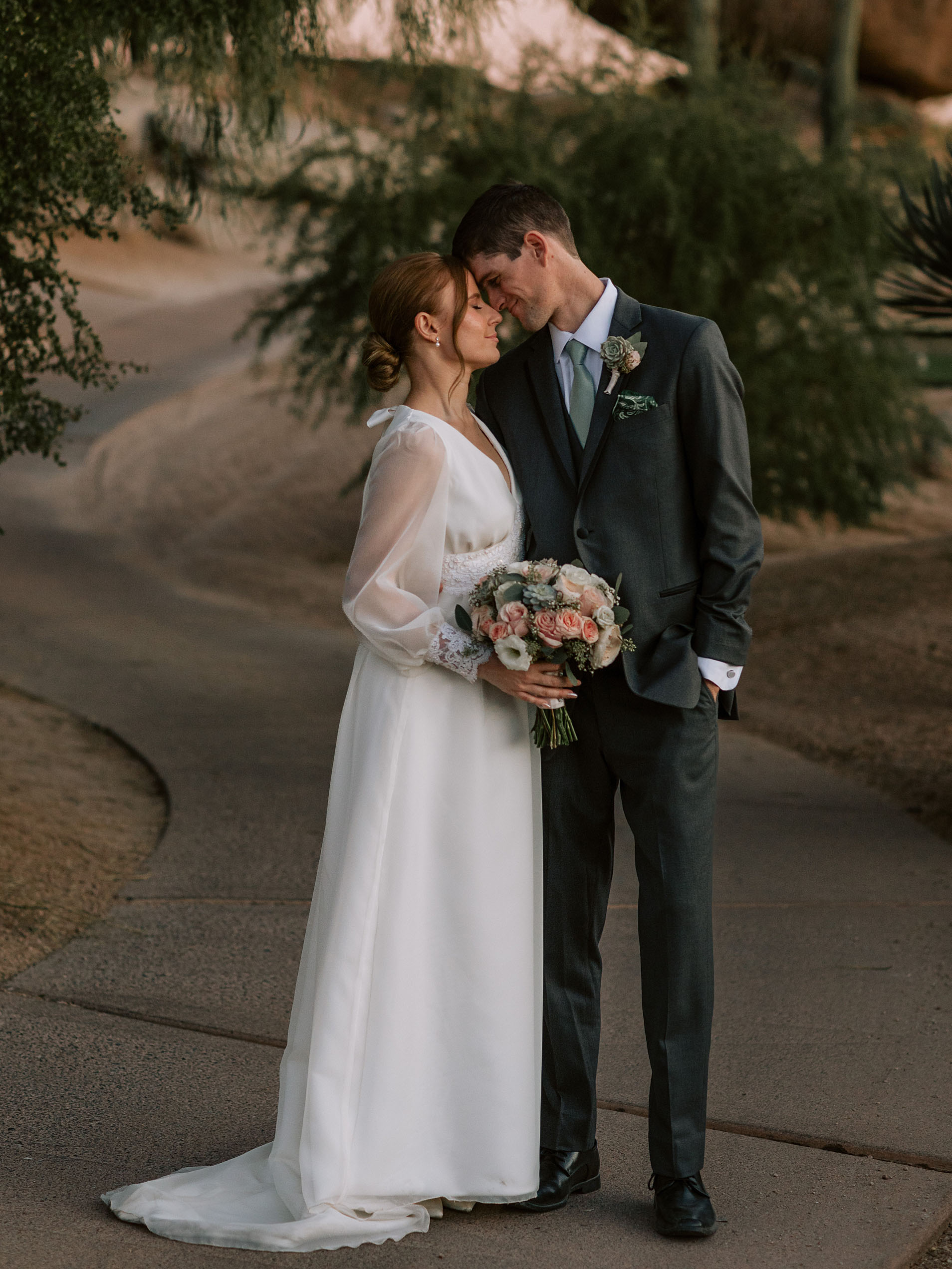 Newlyweds laughing together in the desert garden at The Boulders Resort, capturing a joyful and intimate wedding moment.
