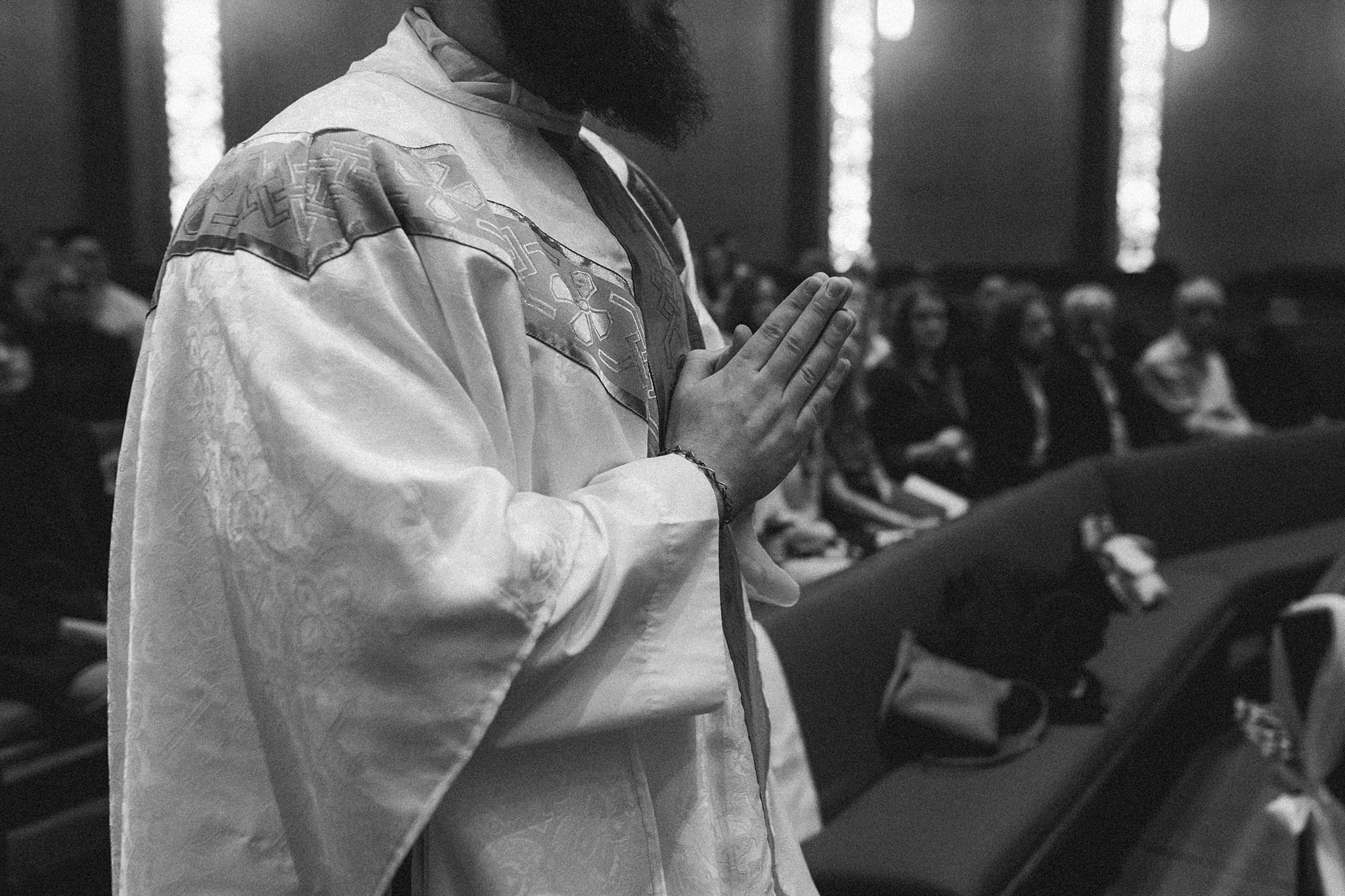 Priest with folded hands at Our Lady of Mount Carmel Catholic Church
