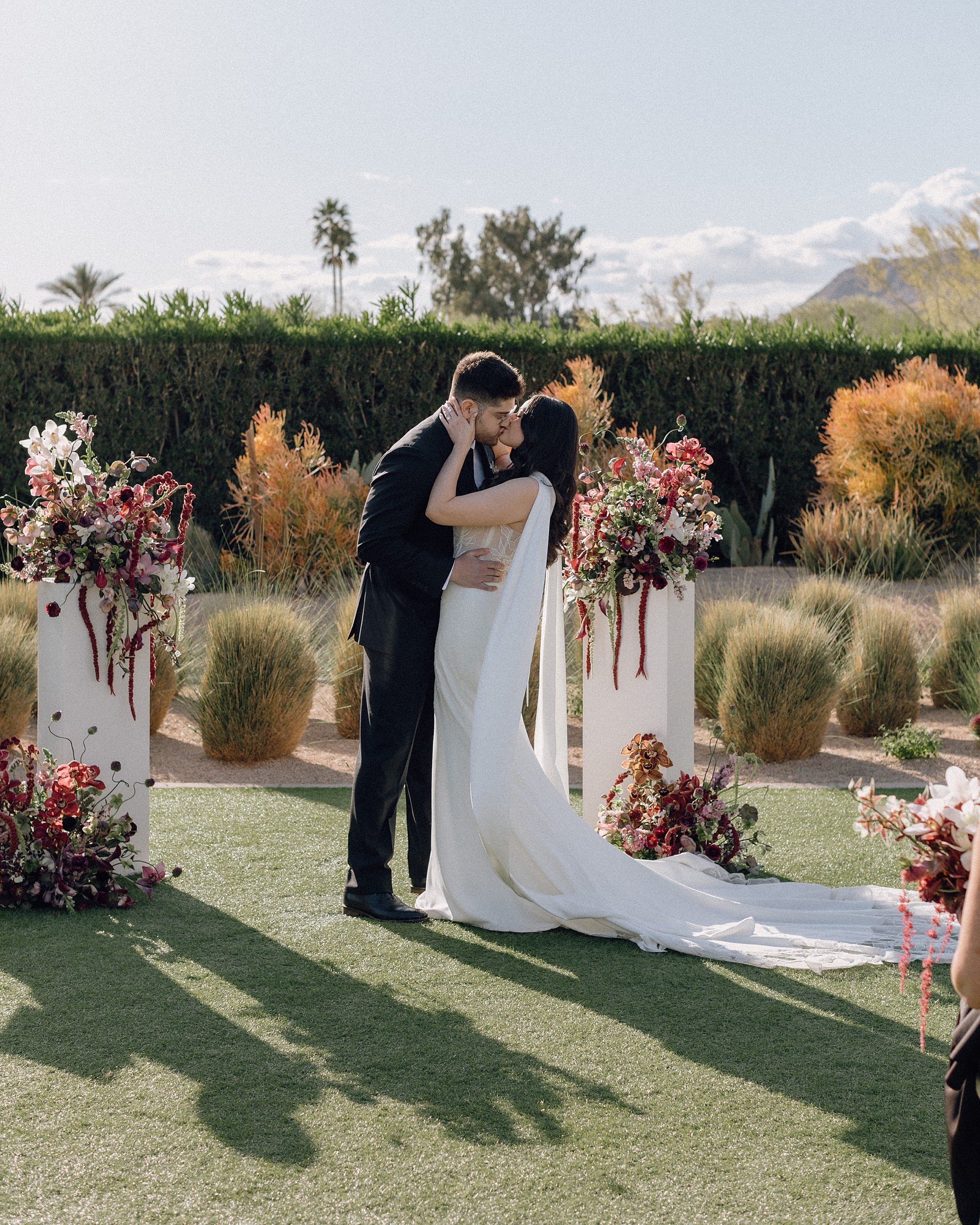 Bride and groom sharing their first kiss under Arizona sky
