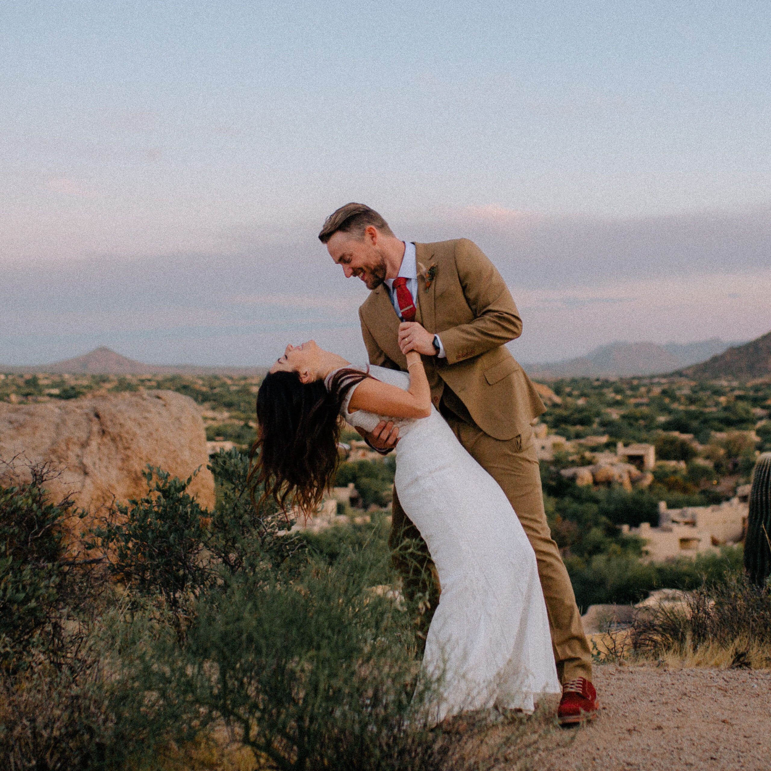How to relax in front of the camera (for wedding photos) Bride and groom dip in the Sonoran desert at sunset. An intimate, candid wedding photo.