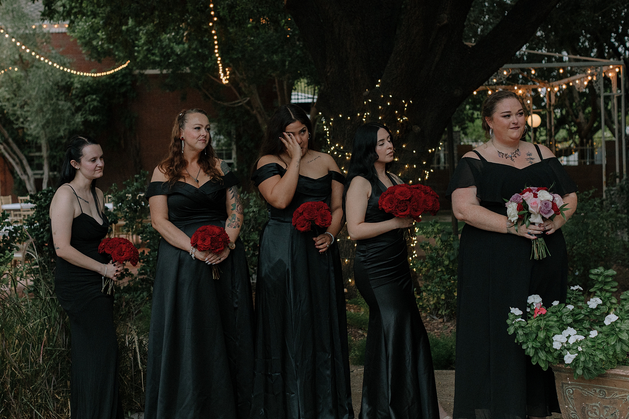 Bridal party in black dresses and red flowers