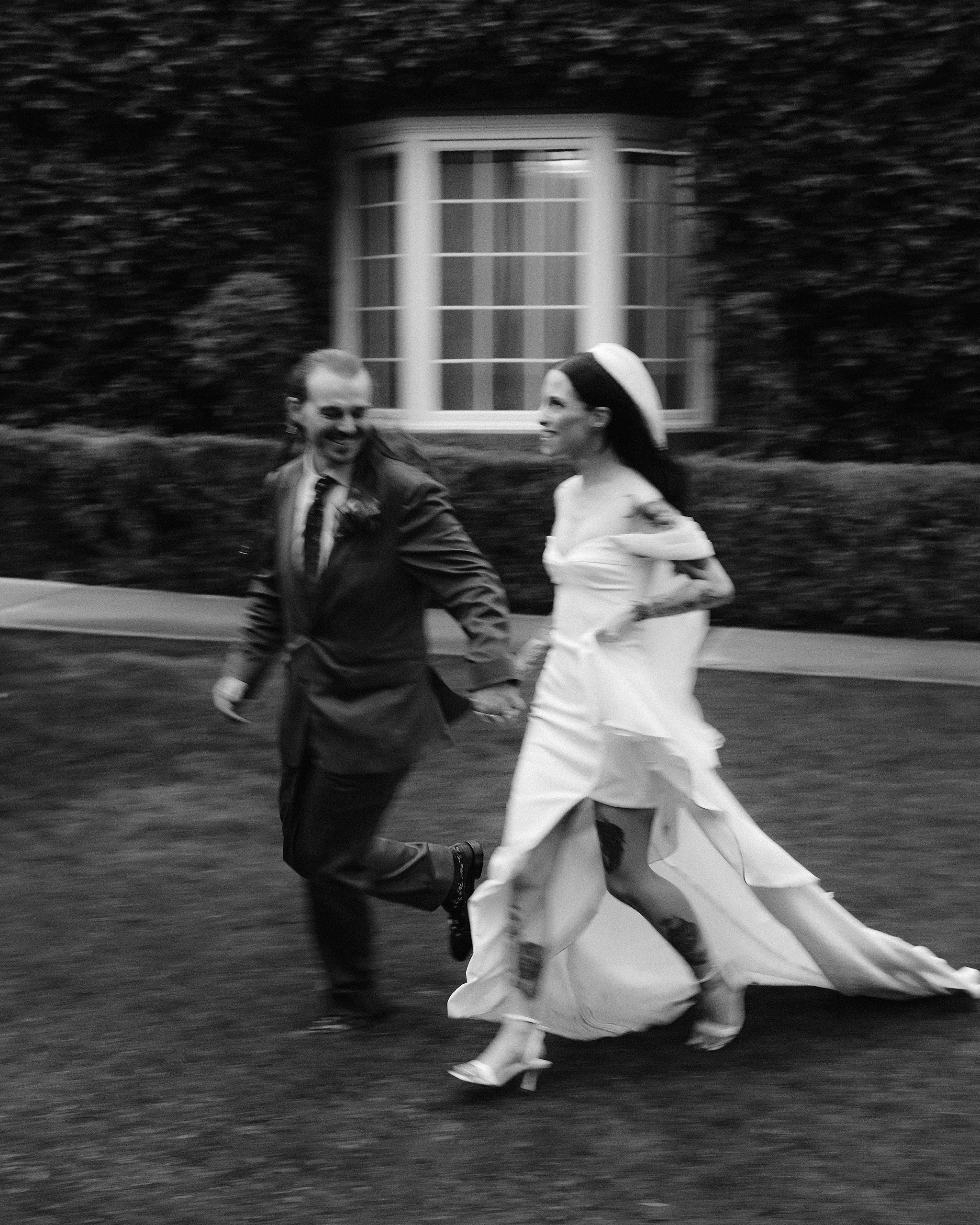 Bride and groom laughing together after the ceremony in the rain