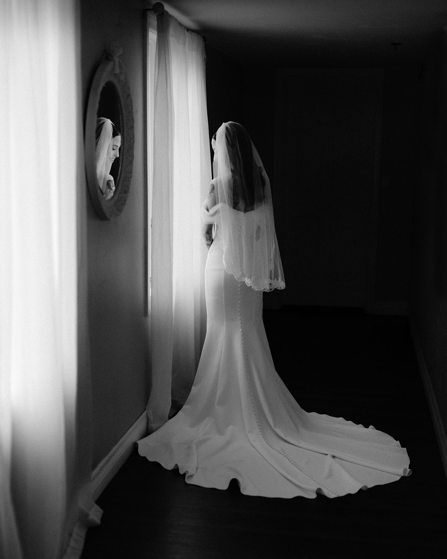 Bride by the window at Stone Bridge Manor before the ceremony