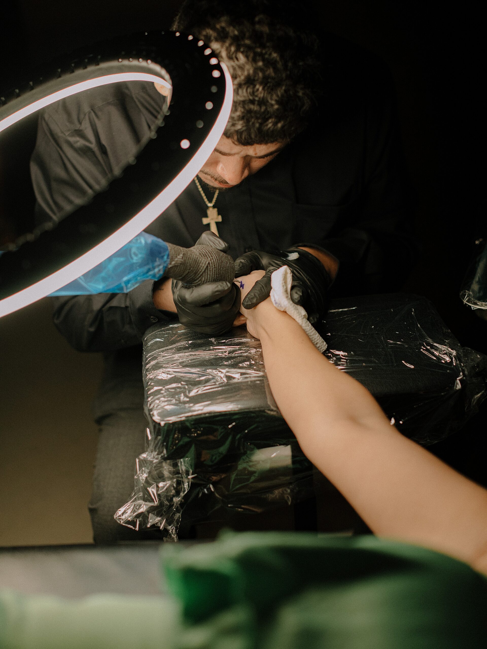 Guests laughing and gathering around the tattoo bar at the wedding reception