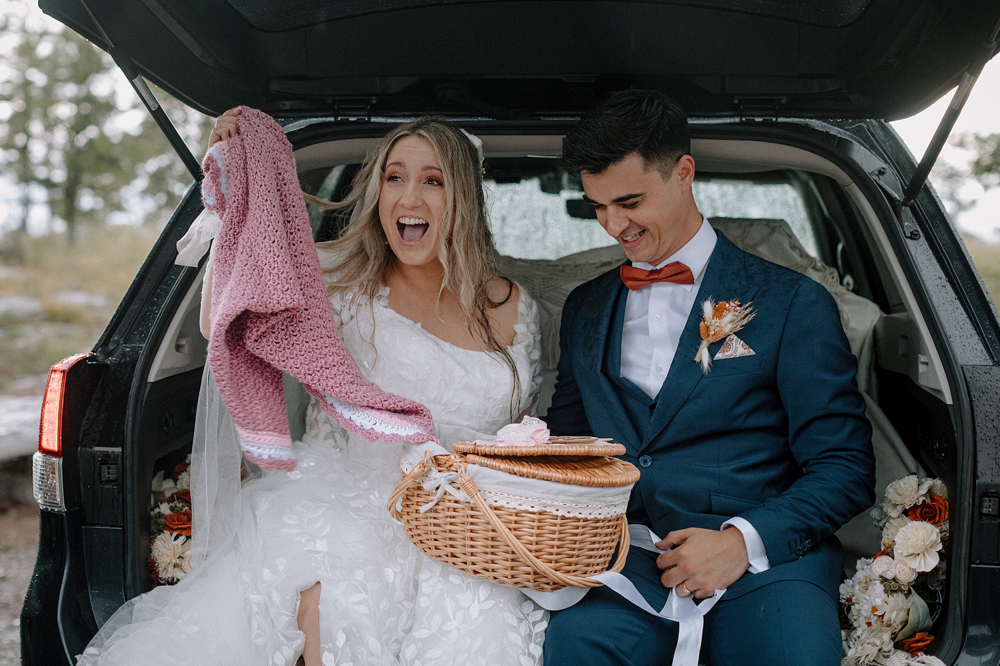 Couple sharing gender reveal after wedding in back of car