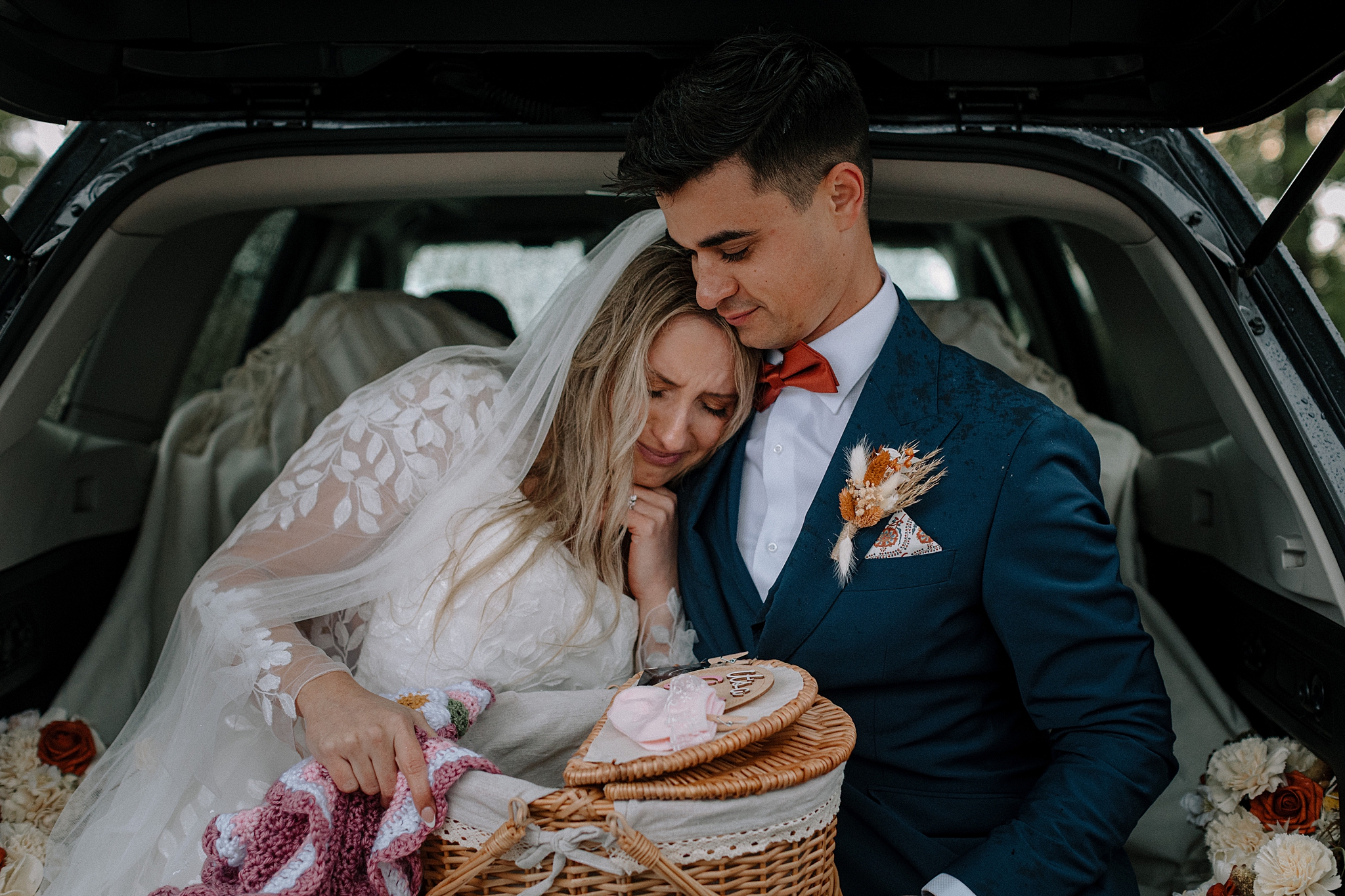 Couple sharing gender reveal after wedding in back of car