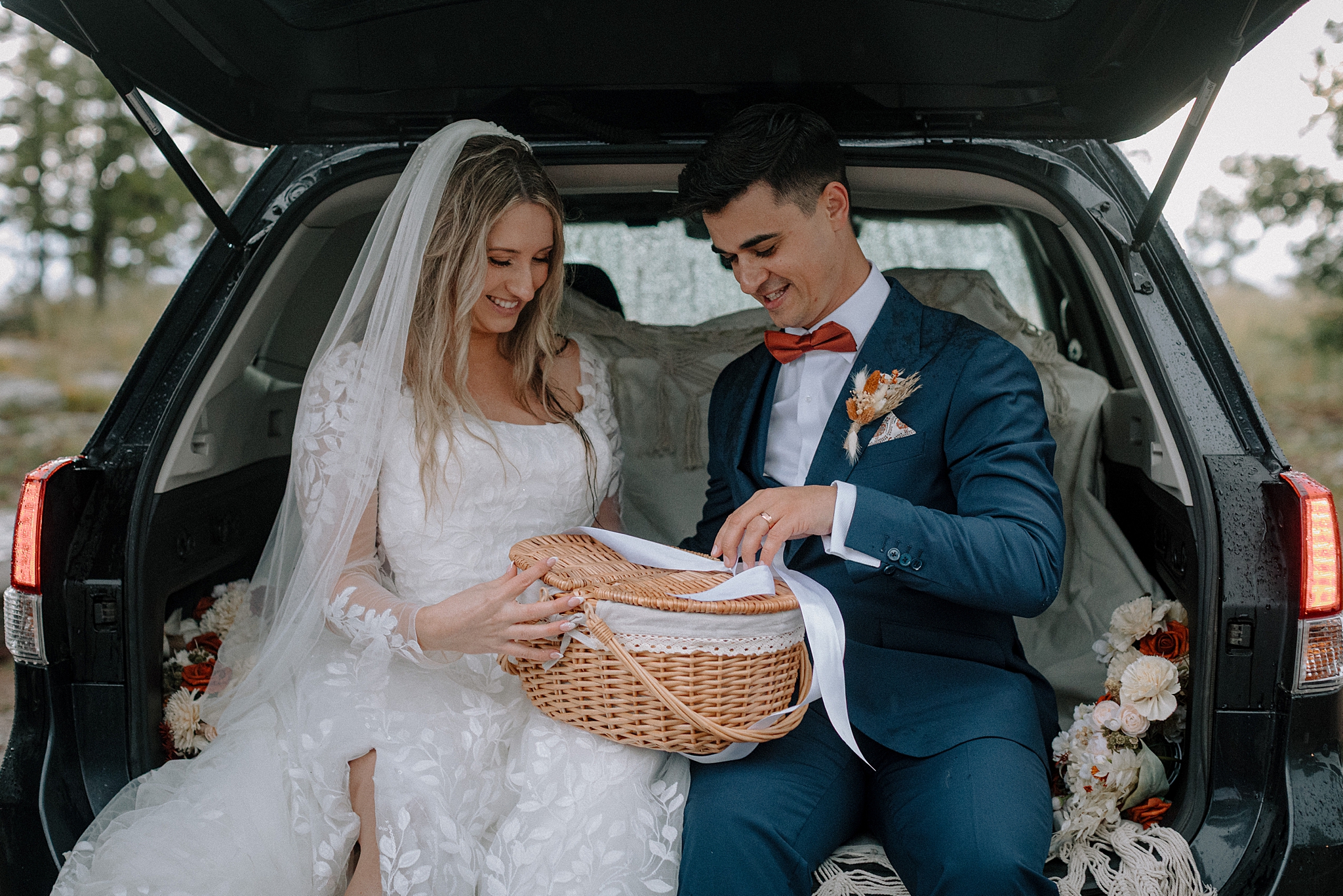 Couple sharing gender reveal after wedding in back of car