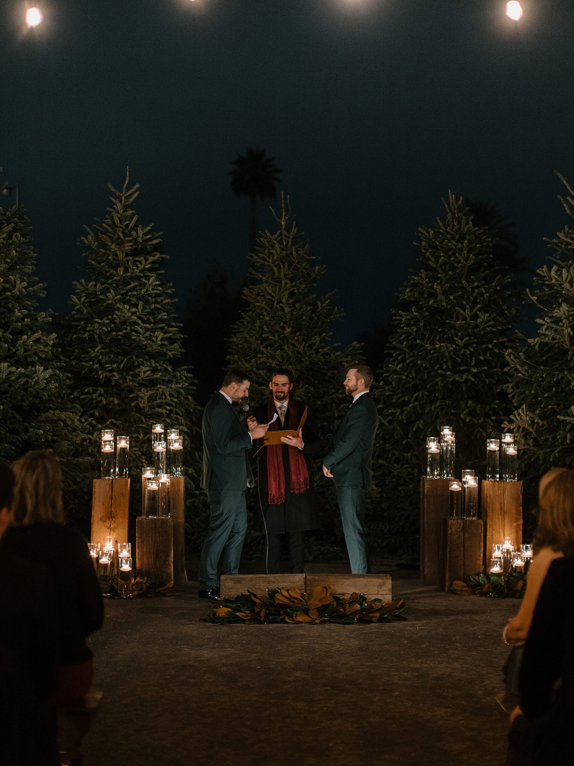 Two grooms at their outdoor candlelit wedding ceremony at Whitfill Nursery in Phoenix