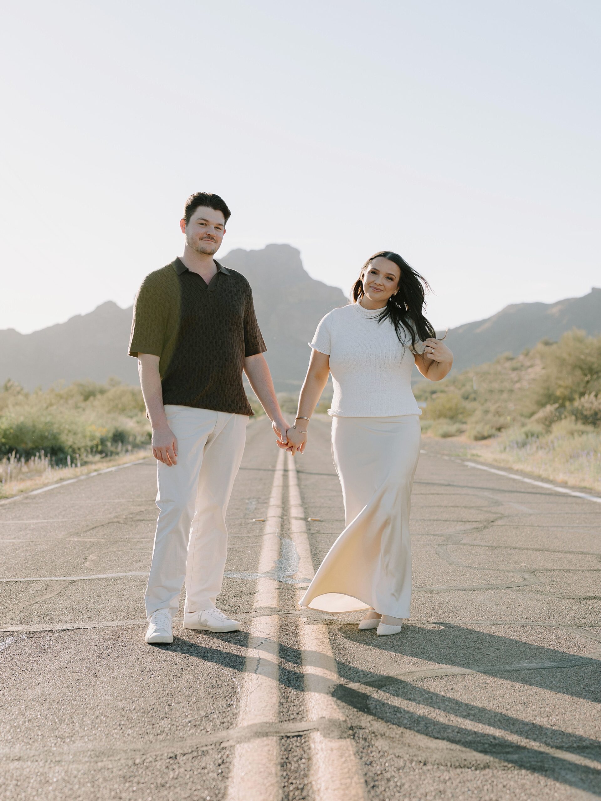 “Couple standing in the middle of Bush Highway during Arizona desert engagement session”