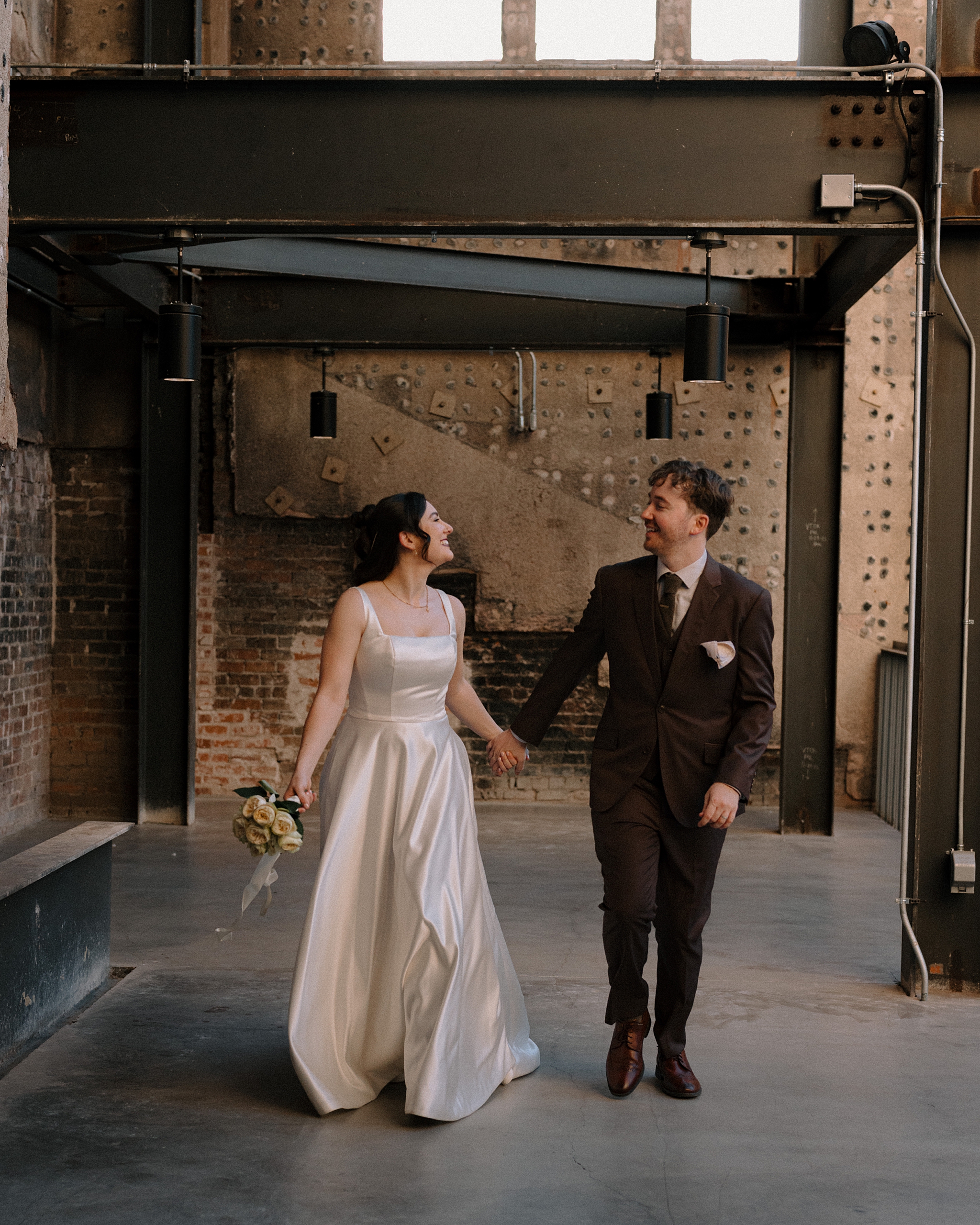 Bride and groom smiling and walking at Monroe Street Abbey in Phoenix Arizona