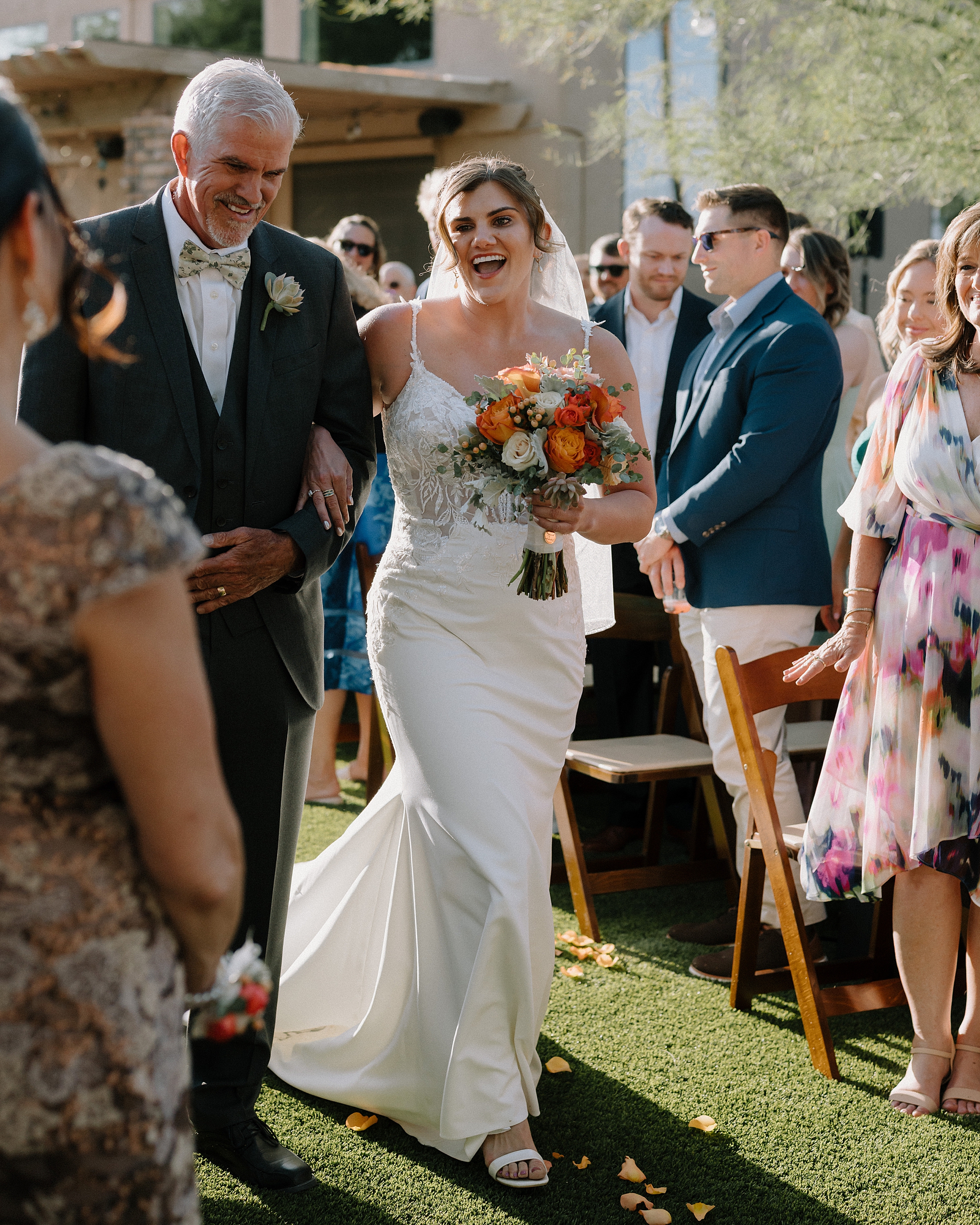 Bride walking down aisle smiling at guests Phoenix backyard wedding