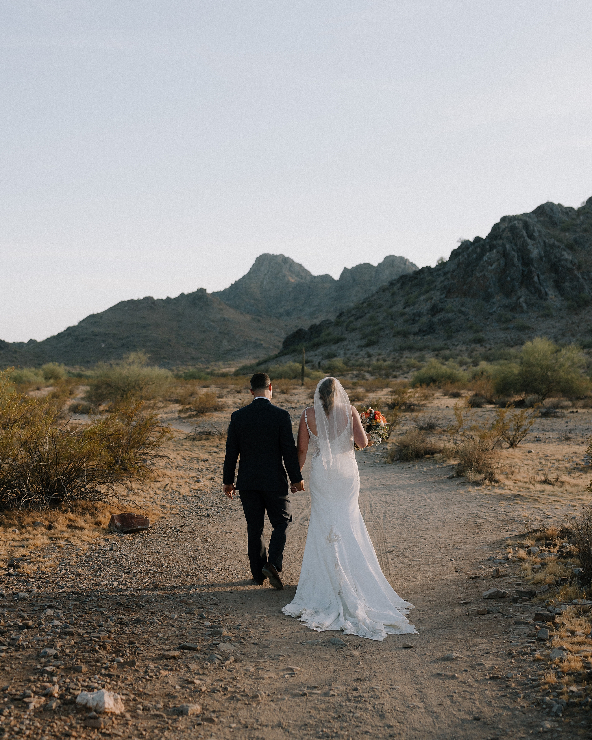 Bride and Groom walking in the Arizona desert at sunset