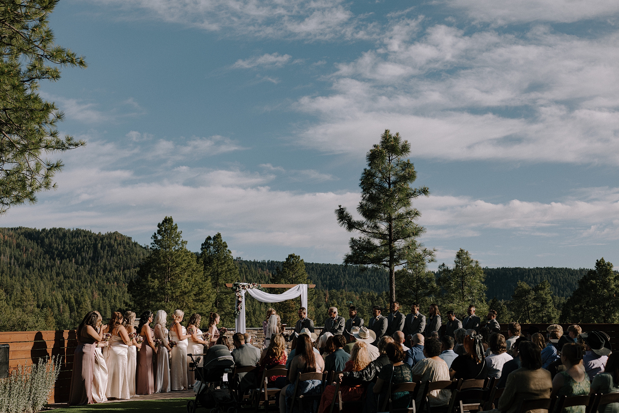 Outdoor wedding ceremony at Cabins on Strawberry Hill with pine trees and mountain views in the background.