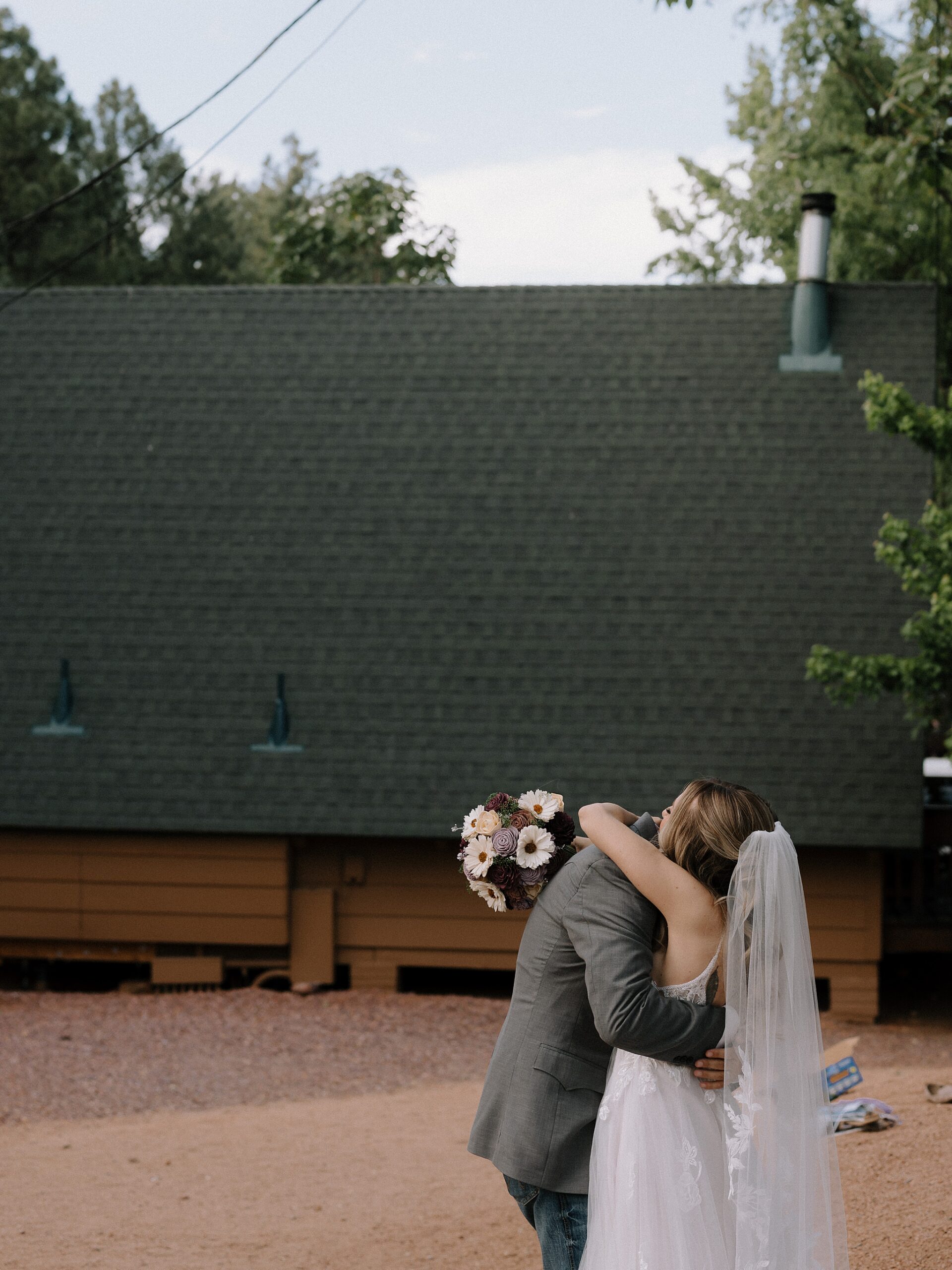 Bride and groom sharing a kiss in the forest after their Strawberry, Arizona wedding ceremony