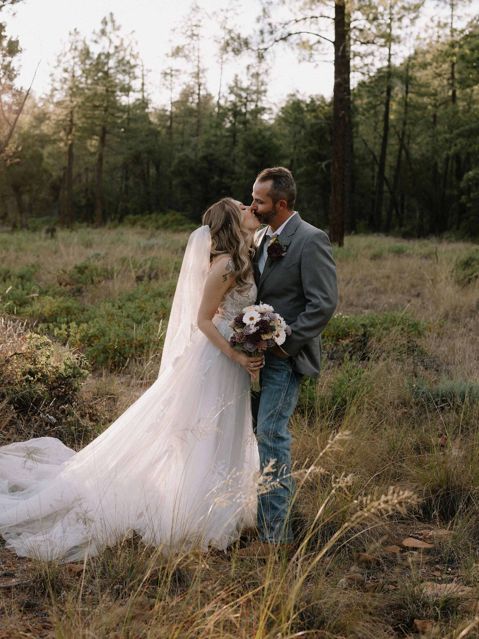 Bride and groom walking through the pines during their Cabins on Strawberry Hill wedding in Strawberry, Arizona.