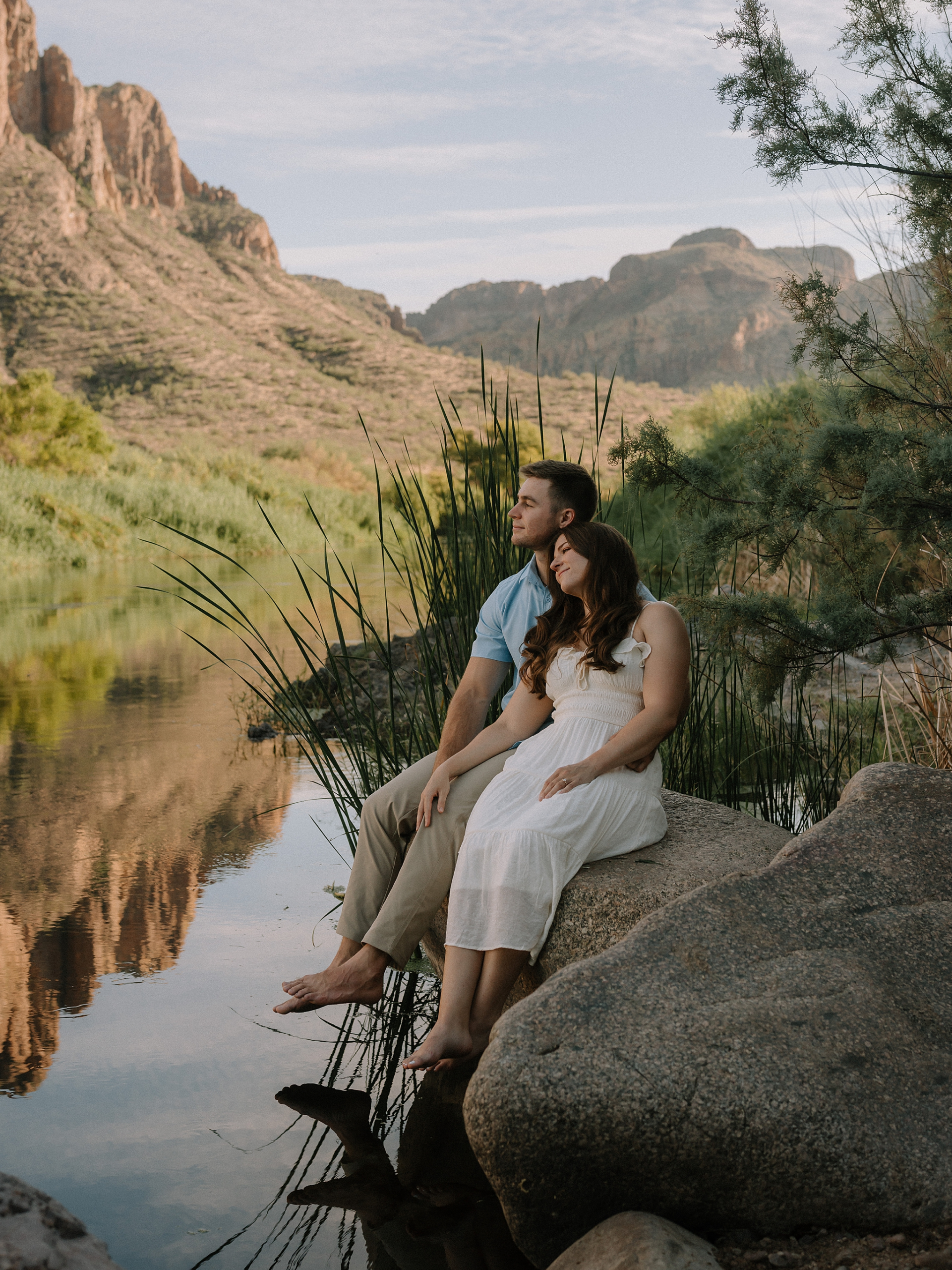 A engagement session in the Salt River, with the couple sitting on the river bank