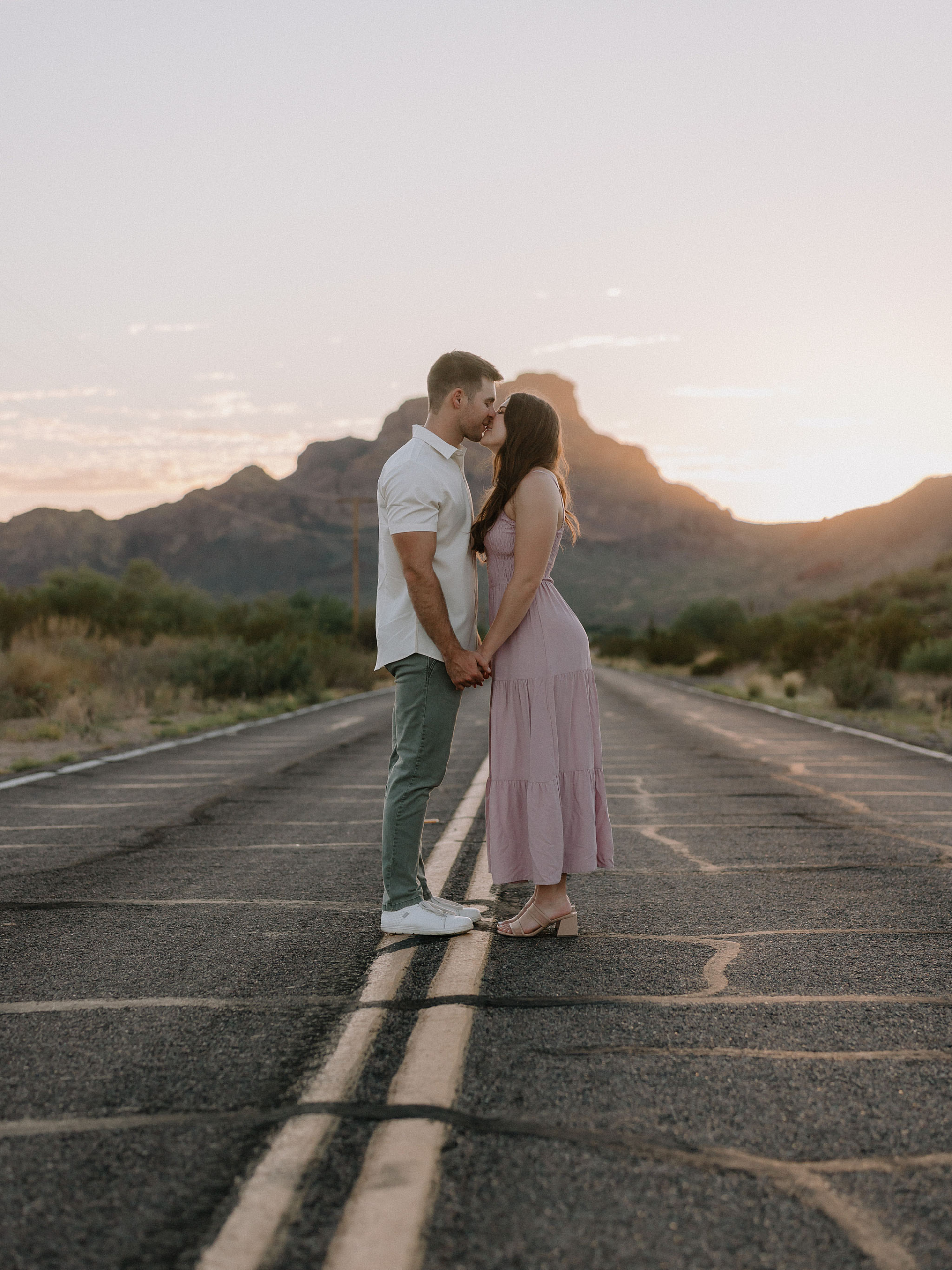 Couple kissing along the salt river with the sun setting in the background